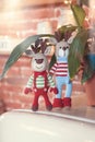 Children toys. Two stylish amigurumi deers in striped sweaters, scarf and butterfly tie standing near flowerpot Royalty Free Stock Photo