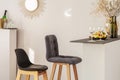 Two stylish bar chairs nest to kitchen island with vine glasses