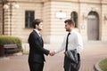 Two stylish businessmen shaking hands in suits