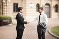 Two stylish businessmen shaking hands in suits