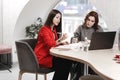 Two stylish girls interior designers working in the office at the design project Royalty Free Stock Photo