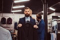 Two stylish shop assistants elegantly dressed working in a menswear store.