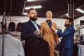 Two stylish shop assistants elegantly dressed working in a menswear store.