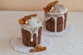 Two stylish traditional Orthodox Easter delicious cakes on the white napkins decorated by dried bananas, orange apricots, almonds