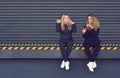 Two stylish young girls sitting and blowing bubbles Royalty Free Stock Photo