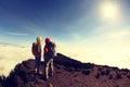 Two successful backpackers enjoy the beautiful landscape on sunrise mountian Royalty Free Stock Photo