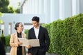 Two successful business people having a discussion while walking outside modern office building Royalty Free Stock Photo