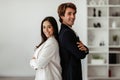 Two successful latin business partners standing back to back with arms crossed and smiling at camera, posing in office Royalty Free Stock Photo