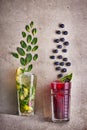 Two summer cocktails at concrete grey background. mojito and blueberry tea. fresh cold drinks concept. Copy space Royalty Free Stock Photo