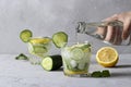 Two summer fresh iced drink with mint, lemon and cucumber, healthy detox mojito cocktail on gray background. Mineral Royalty Free Stock Photo