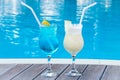Two summer sweet cocktails by the pool. Blue lagoon and Pina colada in a glass with a straw. Mixed alcoholic drink. Beach party Royalty Free Stock Photo