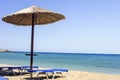 Two sun beds under sun umbrella at the beach in Greece Royalty Free Stock Photo