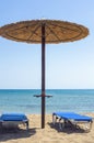 Two sun beds under sun umbrella at the beach in Greece Royalty Free Stock Photo