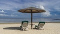 Two sun loungers with soft mattresses stand on the sandy beach under an umbrella Royalty Free Stock Photo