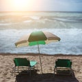 Two sun loungers and an umbrella on a sandy beach by the sea Royalty Free Stock Photo