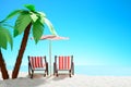 Two sun loungers under a palm tree on the sandy coast. Sky with copy space Royalty Free Stock Photo