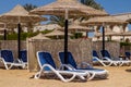 Two sun loungers under an umbrella on the sandy beach. view from the sea. Royalty Free Stock Photo