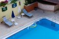 Two sunbeds on the edge of the swimming pool with clean water Royalty Free Stock Photo