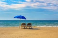 Two sunbeds under an umbrella on the beach