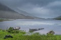 Two sunken boats in Lough Gummeenduff, dramatic storm sky, mist and heavy rain in Blackvalley