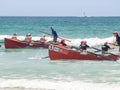 Two surf-boats and crew returning to shore racing as the ride the small waves in