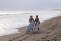 Two surfers couple go on the ocean beach with longboards in hand Royalty Free Stock Photo