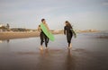 Two Surfers Man And Woman Walking With Surfboards Along The Beach Royalty Free Stock Photo