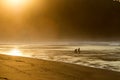 Two surfers sit on the shore of the ocean watching the sunset. Royalty Free Stock Photo