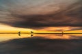 surfers on an island at sunset on a cloudy day Royalty Free Stock Photo