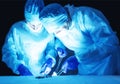 Two surgeons, a man and a woman, perform surgery to remove prostate adenoma and varicocele, fibroadenoma