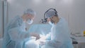 Two surgeons perform operation on man. Action. Surgeons professionally perform operation on patient under anesthesia Royalty Free Stock Photo