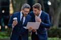 Two surprised young businessmen in classic suits using laptop. Businessmen looking laptop with their business success in Royalty Free Stock Photo