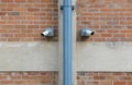Two surveillance cameras on red brick wall Royalty Free Stock Photo
