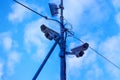 Two surveillance cameras and a transmitter on a pole in the city against Royalty Free Stock Photo