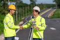 Two surveyor engineers worker handshake after making measuring with theodolite instrument equipment during construction road works Royalty Free Stock Photo