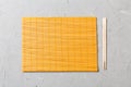 Two sushi chopsticks with empty bamboo mat or wood plate on stone Background Top view with copy stace Royalty Free Stock Photo
