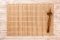 Two sushi chopsticks with empty brown bamboo mat or wood plate on brown wooden Background Top view with copy space. empty asian Royalty Free Stock Photo