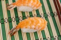 Two sushi with fresh nigiri prawns on a light green background