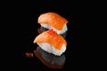 Sushi nigiri with salmon - Syake with red caviar on a black background with reflection. A dish of rice and red fish Royalty Free Stock Photo