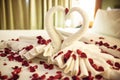 Two swans made from towels are kissing on honeymoon white bed. Royalty Free Stock Photo