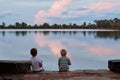 Two sweating tired boys rest evening sunset near lake. Angkor Wat, Cambodia