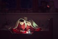 Two sweet boys, reading a book in bed after bedtime, using flash Royalty Free Stock Photo