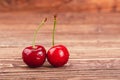 Two sweet cherry berries on the wooden background Royalty Free Stock Photo