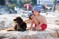 Two sweet children, boys, playing with dog on the beach Royalty Free Stock Photo