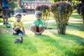 Two sweet little boy and Pennon rabbit bunnies are sitting on green grass. Friendship between humans and animals. Children and