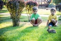 Two sweet little boy and Pennon rabbit bunnies are sitting on green grass. Friendship between humans and animals. Children and