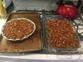 Two sweet potato casseroles topped with roasted pecans