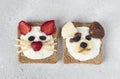 Two sweet toasts for kids in shape of cat and dog with strawberries, banana, cream cheese, chocolate and coconut flakes Royalty Free Stock Photo