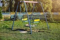 Two swings on children playground. Outdoors games for kids. Summer day Royalty Free Stock Photo