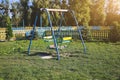 Two swings on children playground. Outdoors games for kids. Summer day Royalty Free Stock Photo